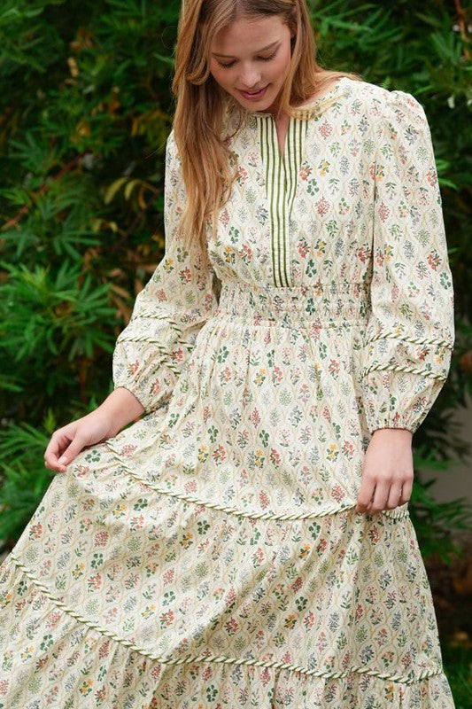 ModestAndDevoted novelty print maxi dress with pockets and detailed trim, flowing design, and vibrant pattern.