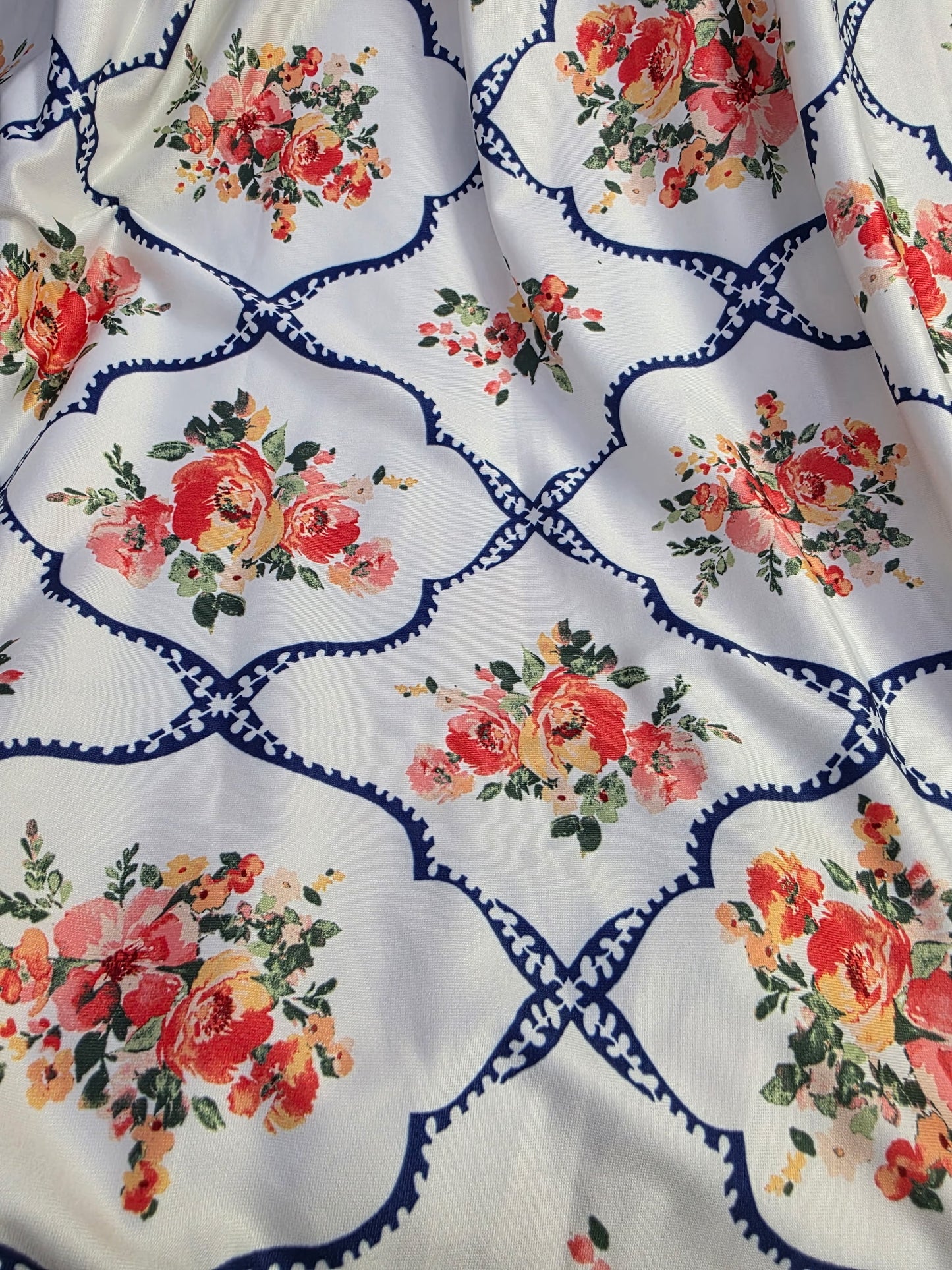 Pink floral lattice print dress with a tie waist from ModestAndDevoted, featuring a flattering silhouette and vibrant floral pattern.