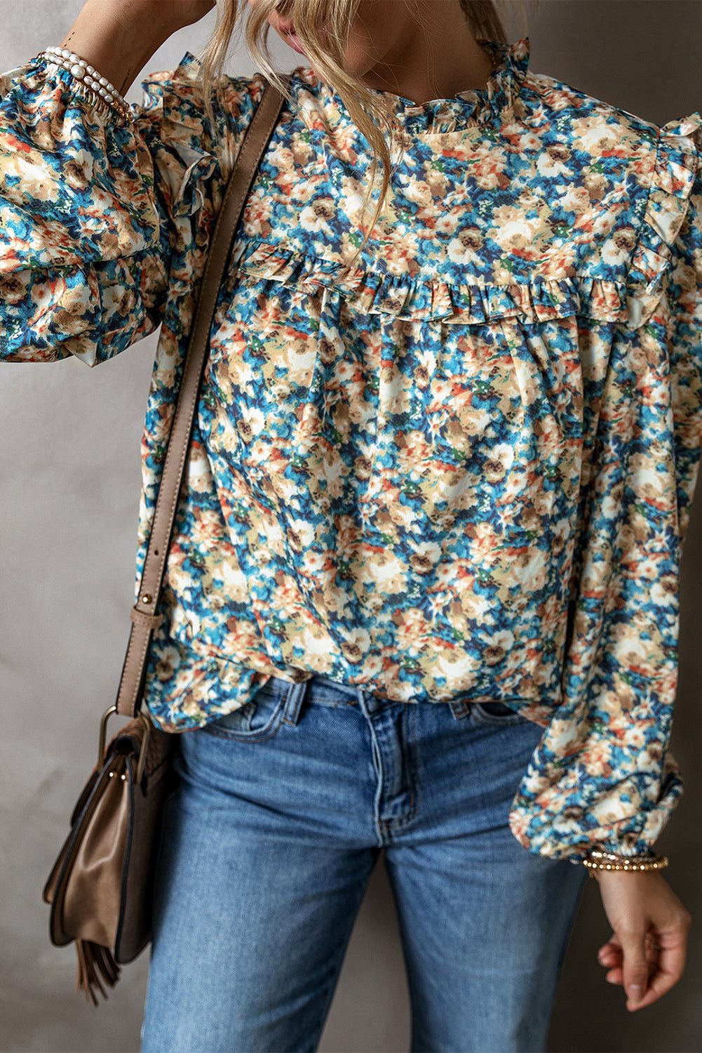 Sky blue floral print blouse with frilled mock neck and puff sleeves by ModestAndDevoted, made of lightweight polyester fabric.