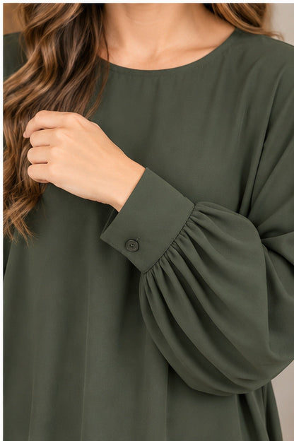 Closeup of gathered sleeve and button cuff on Andree olive blouse