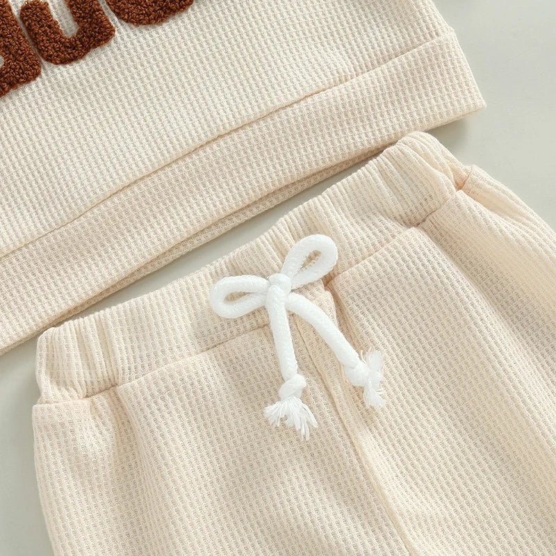 Baby toddler boys beige 2-piece waffle outfit with letter embroidery, long sleeve top, elastic waist solid pants by August + Willow.