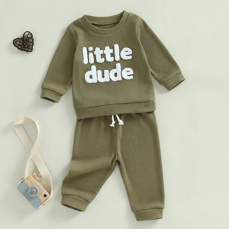 Baby toddler boys 2-piece waffle outfit with letter embroidery, long sleeve top, elastic waist solid pants in beige by August + Willow.