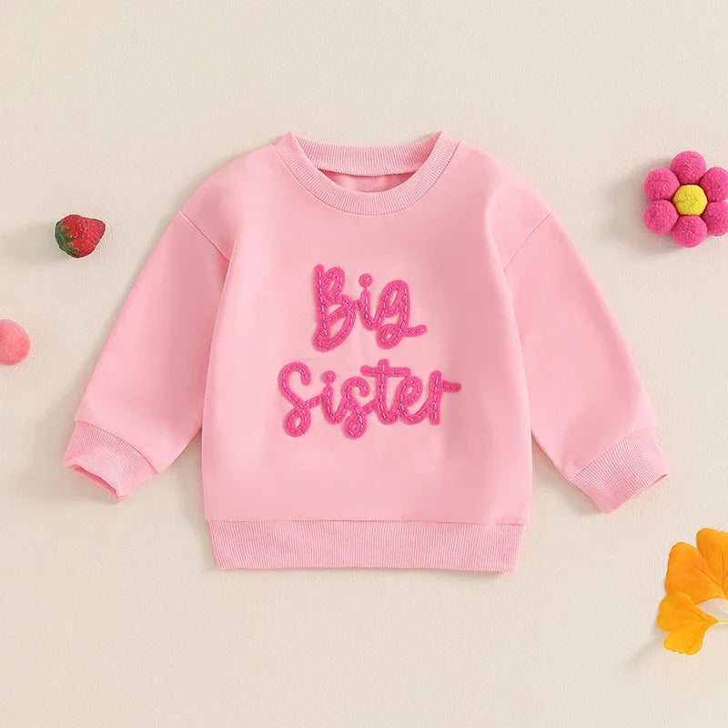 Beige toddler girls' long sleeve crewneck pullover top with embroidered letter design, loose fit, by August + Willow.