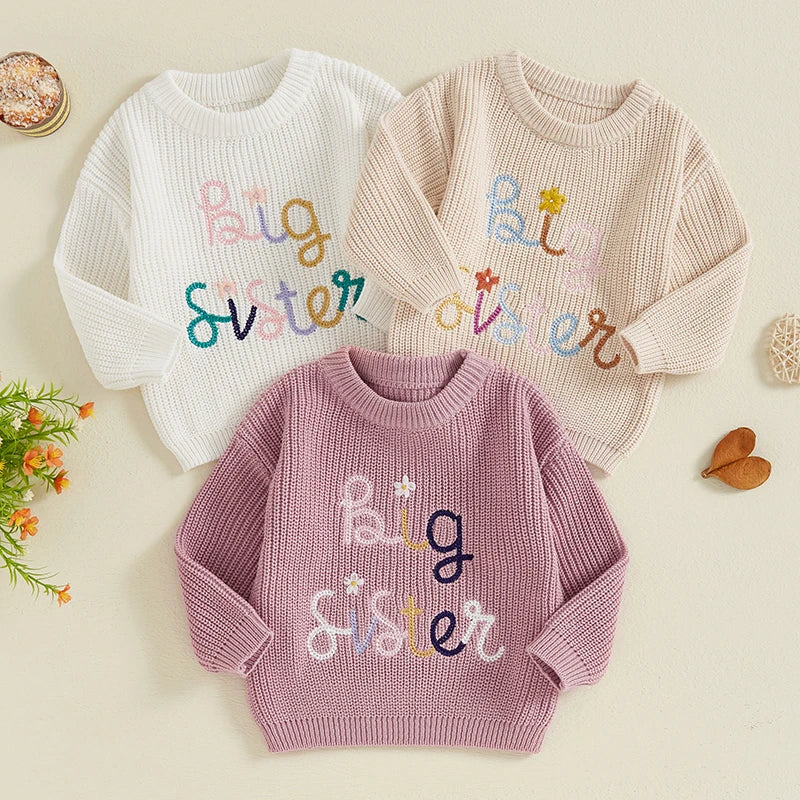 Baby girl toddler sweater by August + Willow featuring letter and flower embroidery, crew neck, long sleeves, beige color.