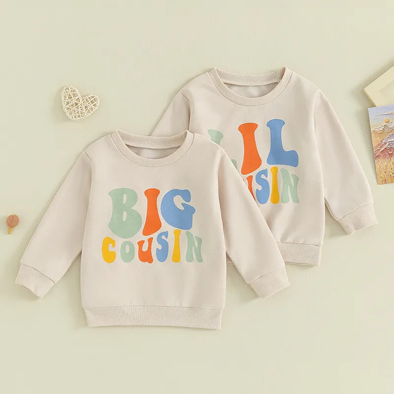 Baby and toddler girls and boys matching beige long sleeve crewneck tops with letter print "Big Lil Cousin" by August + Willow.