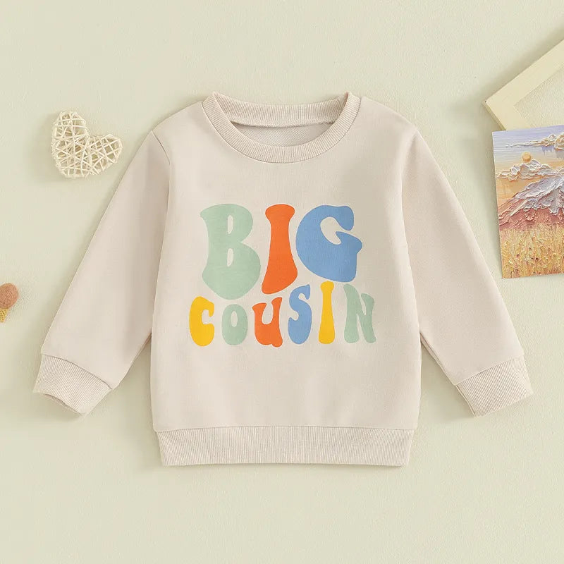 Baby and toddler matching beige letter print crewneck tops for girls and boys, by August + Willow, featuring "Lil Cousin" design.