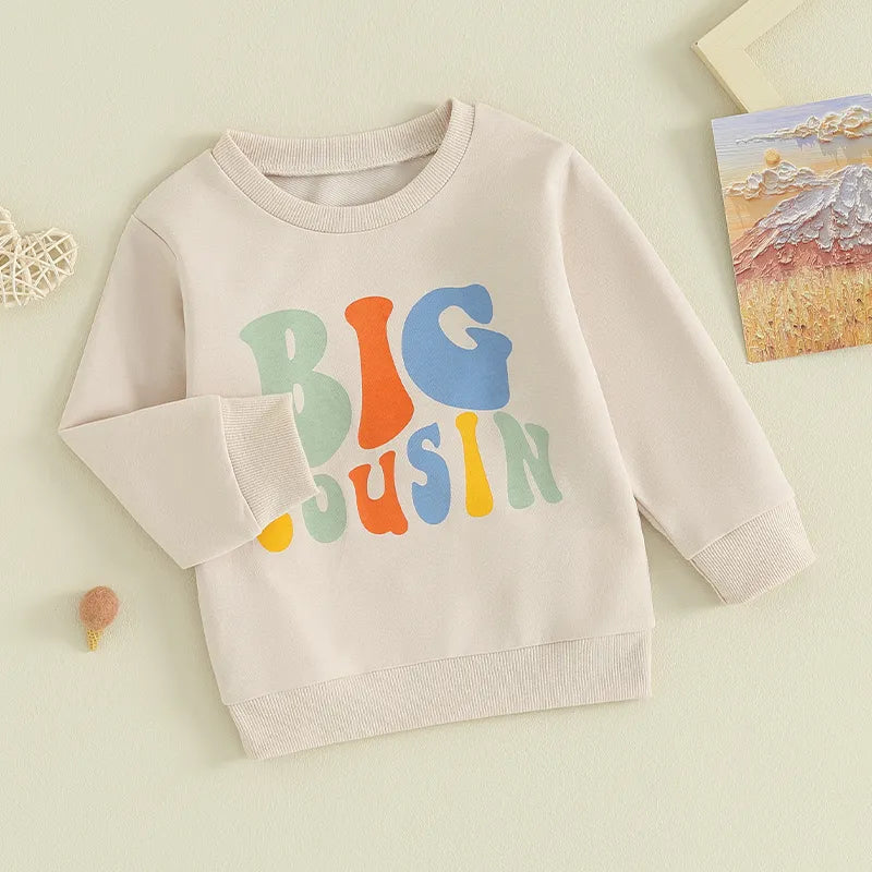 Baby and toddler girls and boys matching beige long sleeve crewneck top with letter print and "Lil Cousin" design by August + Willow.