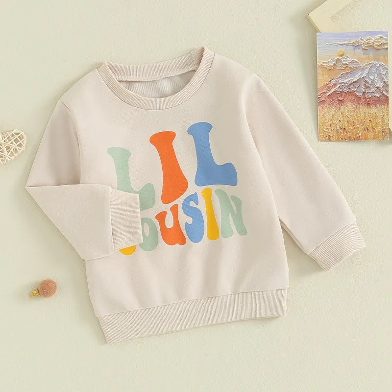 Baby and toddler girls and boys matching beige crewneck tops with letter print and "Big Lil Cousin" design by August + Willow.
