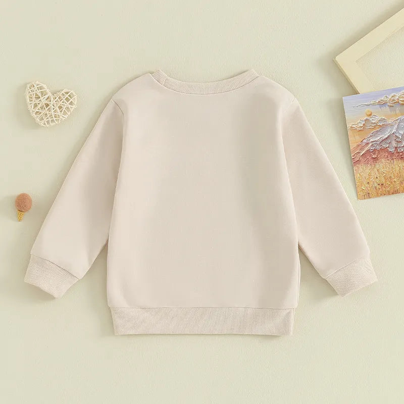Baby and toddler girls and boys matching beige long sleeve crewneck tops with letter print and "Lil Cousin" design by August + Willow.