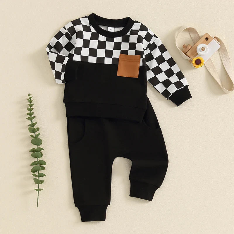 Baby toddler boys fall outfit set from August + Willow featuring a black checkerboard long-sleeve top with pocket and solid pants.