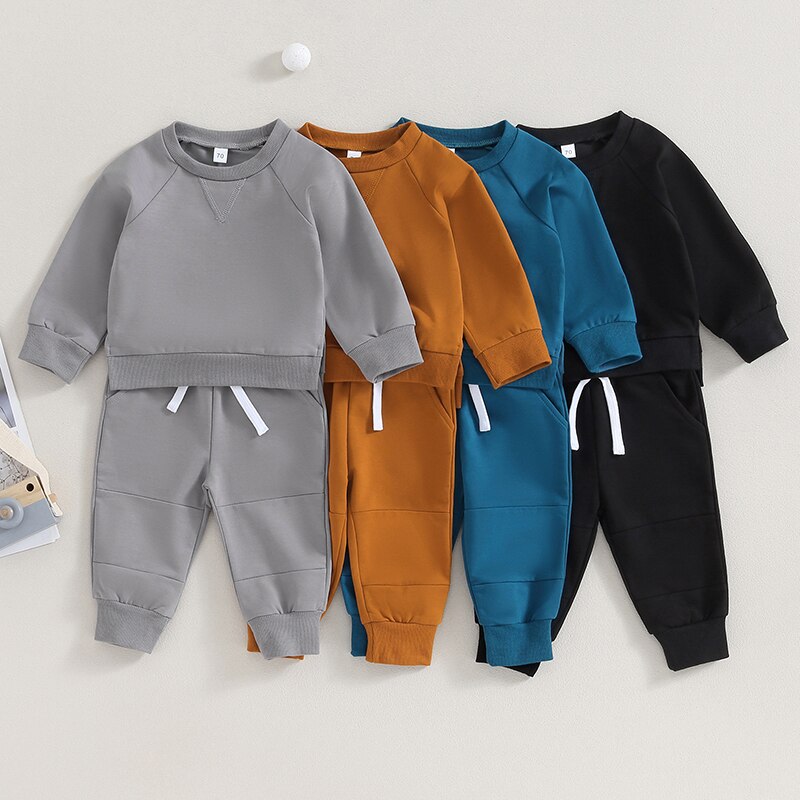 Toddler girls and boys fall outfits by August + Willow with long sleeve split hem tops and solid color pocket pants.
