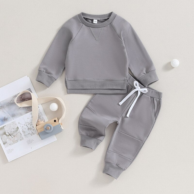 Toddler boys and girls fall outfit set with long sleeve split hem tops and solid color pocket pants from August + Willow.