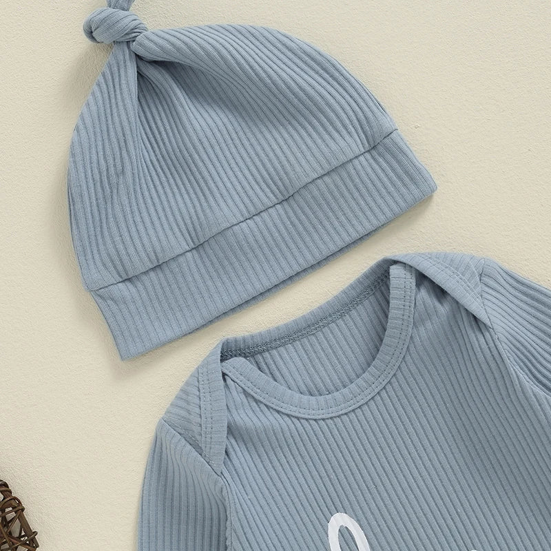 Baby boy or girl in a blue 2-piece romper and hat set with "Hi I'm New Here" letter print, long sleeves, and crew neck.