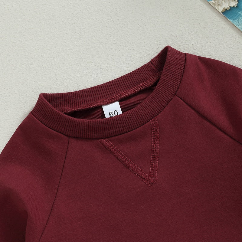 Baby girls and boys burgundy long sleeve bodysuit with crew neck, solid jumpsuit by August + Willow, perfect fall toddler outfit.