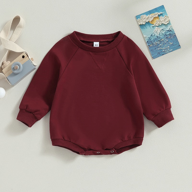 Baby boys and girls long sleeve bodysuit by August + Willow, solid burgundy jumpsuit with crew neck and fall-themed style.