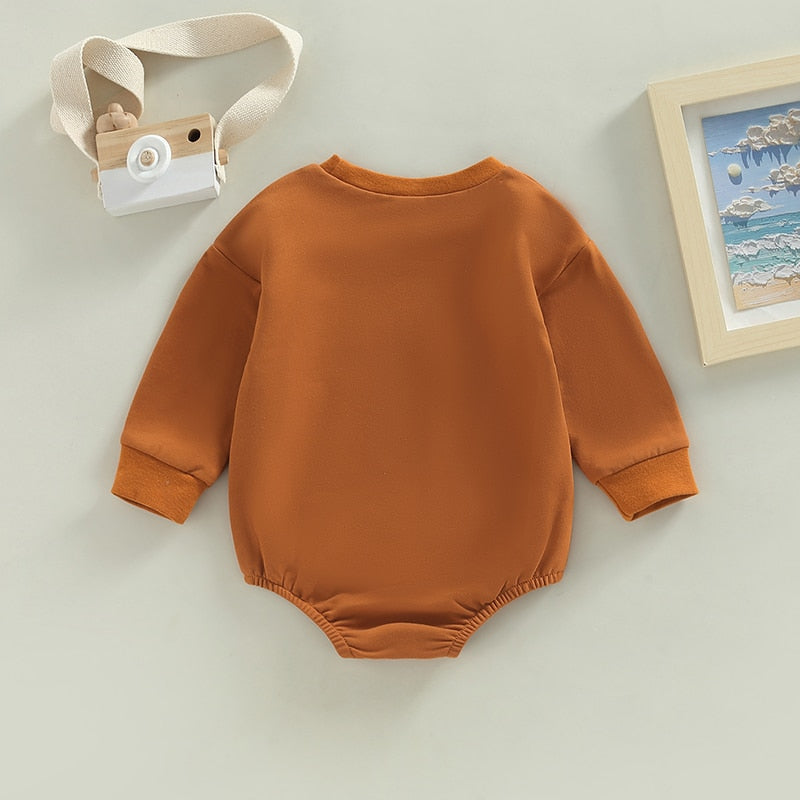 Baby boy or girl in August + Willow long sleeve bubble romper with coffee date print, perfect for infants and toddlers.