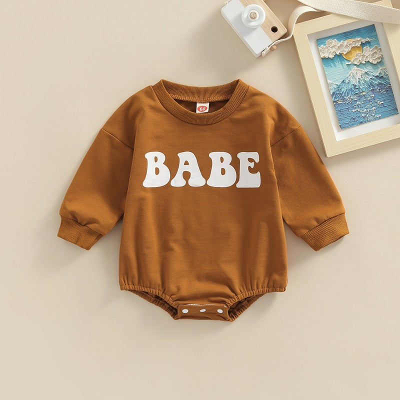 Adorable baby boy and girl long sleeve BABE bubble romper by August + Willow in green for ages 0-3 months.