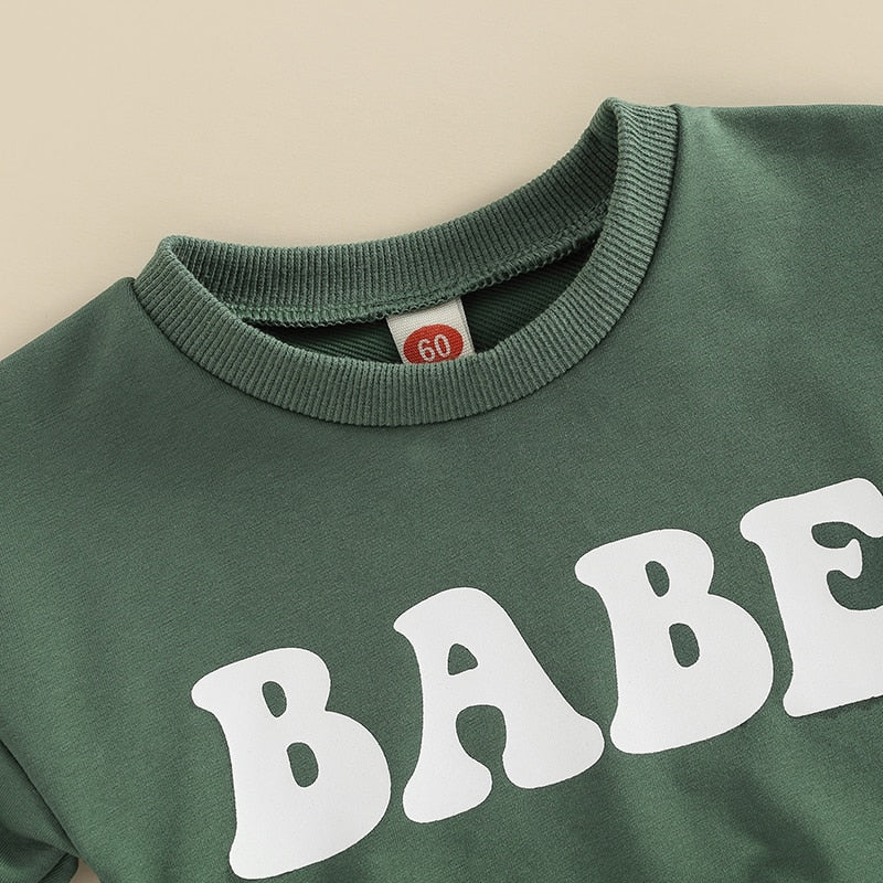 Adorable green long sleeve baby romper for boys and girls from August + Willow, perfect for infants aged 0-3 months.