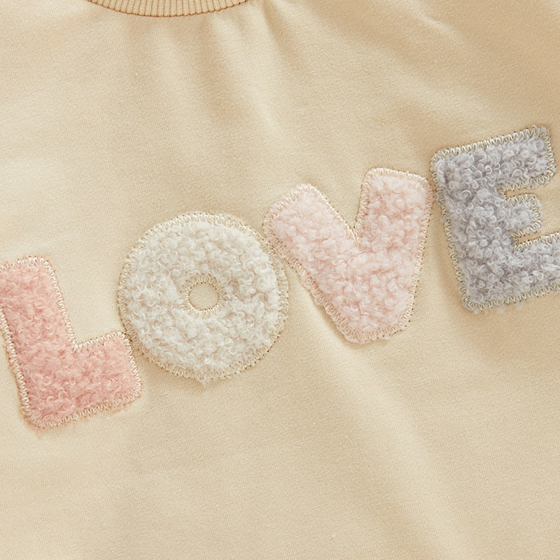 Baby girl fall bodysuit by August + Willow, fuzzy letter love print, long sleeves, round neck, cream color, toddler outfit.