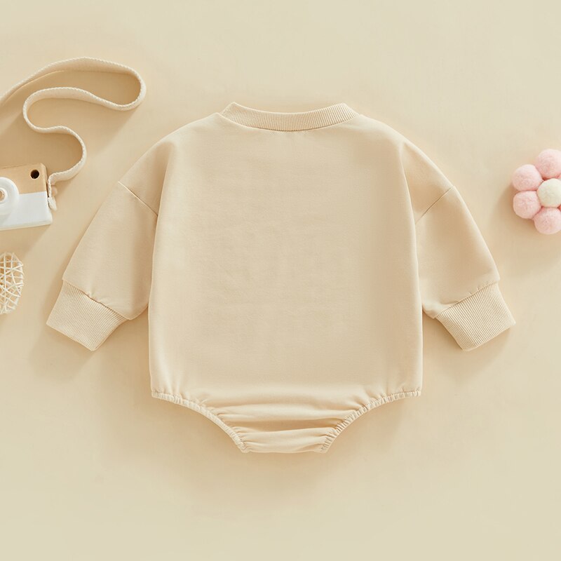 Light cream baby girl fall bodysuit by August + Willow with fuzzy letter love print, long sleeves, round neck, and bubble romper style.
