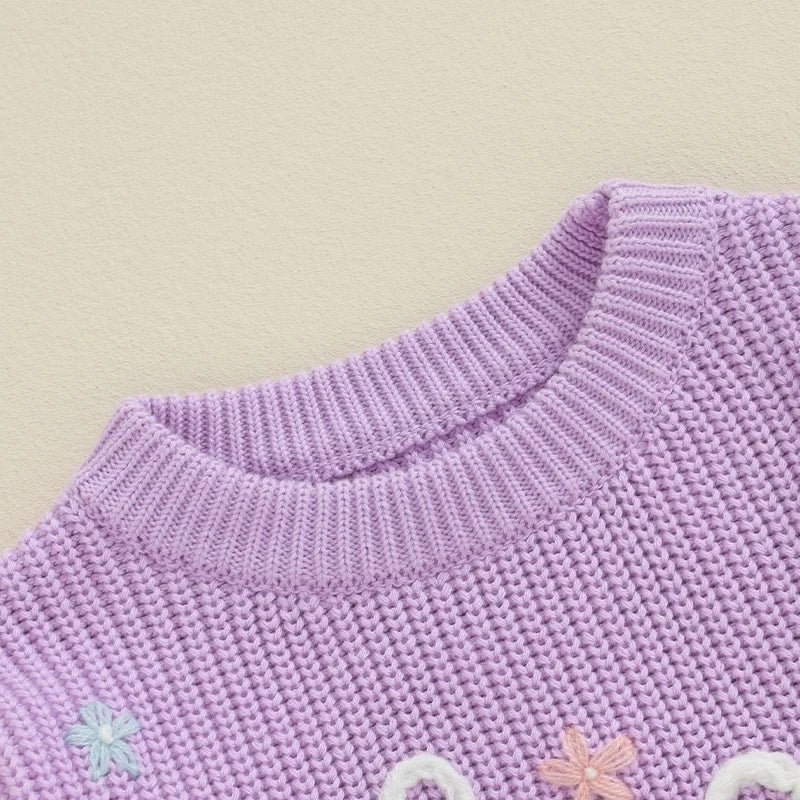 Light pink toddler girl sweater by August + Willow featuring long sleeves, letter embroidery, and a loose knit pullover design.