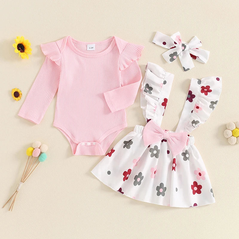 Baby girl fall outfit set by August + Willow with a long-sleeve ribbed romper, flower print skirt, suspenders, and headband.
