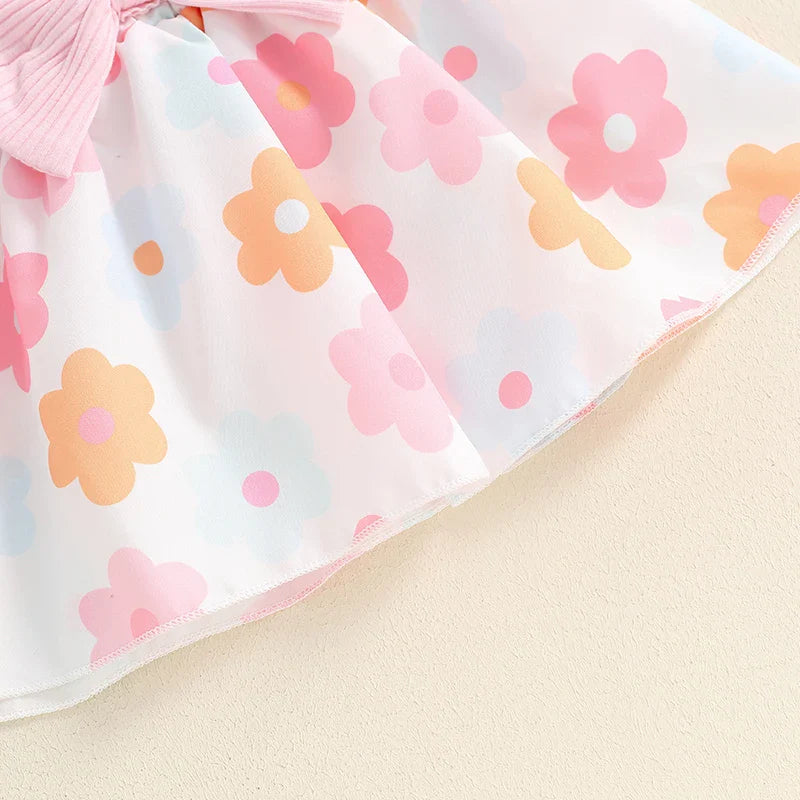Baby girls' fall outfit set with long sleeve ribbed romper, bow suspender flower print skirt, and headband by August + Willow.
