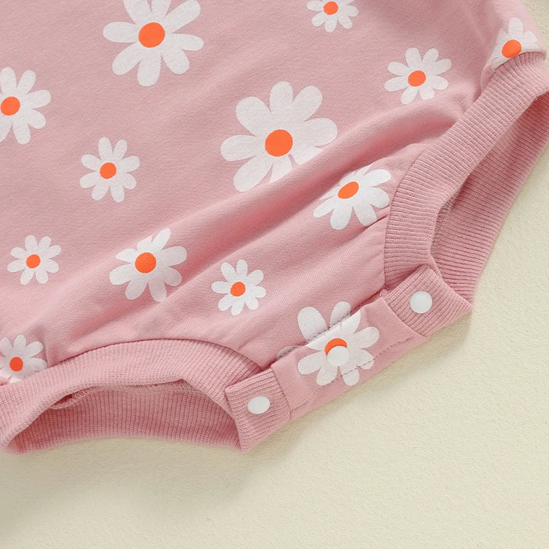 Baby girl bubble romper in purple with daisy flower print, long sleeves, round neck, from August + Willow baby and toddler outfits.