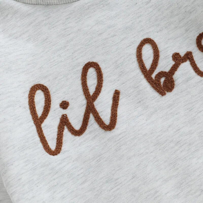 Baby boy long sleeve crewneck romper by August + Willow featuring "Big Lil Bro" letters, perfect for matching brother outfits.