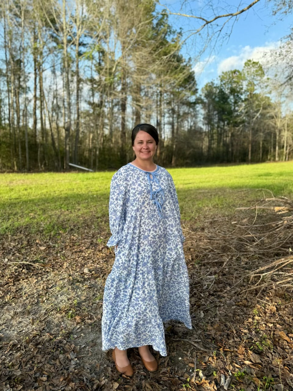 French blue floral maxi dress by Celeste Clothing featuring gauze-like fabric and a bow accent, displayed on a model.