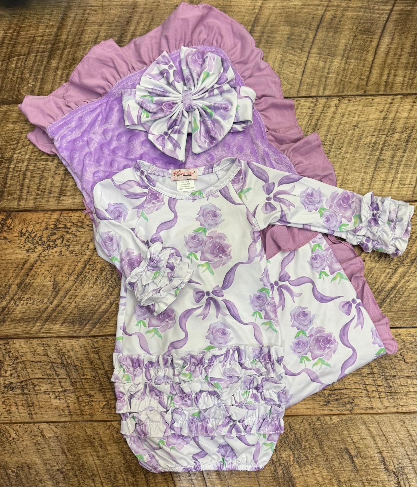 Newborn gift set by Clover Cottage with pink gown, matching headwear, and blanket, ideal for a baby.