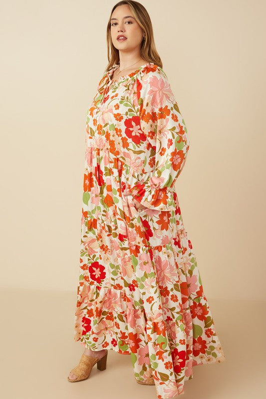 Women's satin floral tie-neck tiered maxi dress by Hayden Los Angeles, shown with flowing fabric and floral pattern.