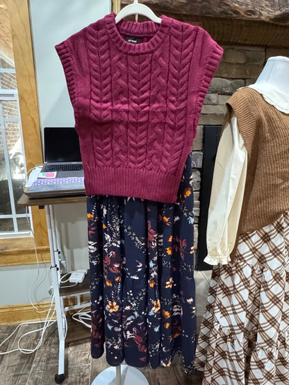Front of Heyson burgundy cable-knit sweater vest with crew neckline and ribbed trim; floral skirt shown for styling
