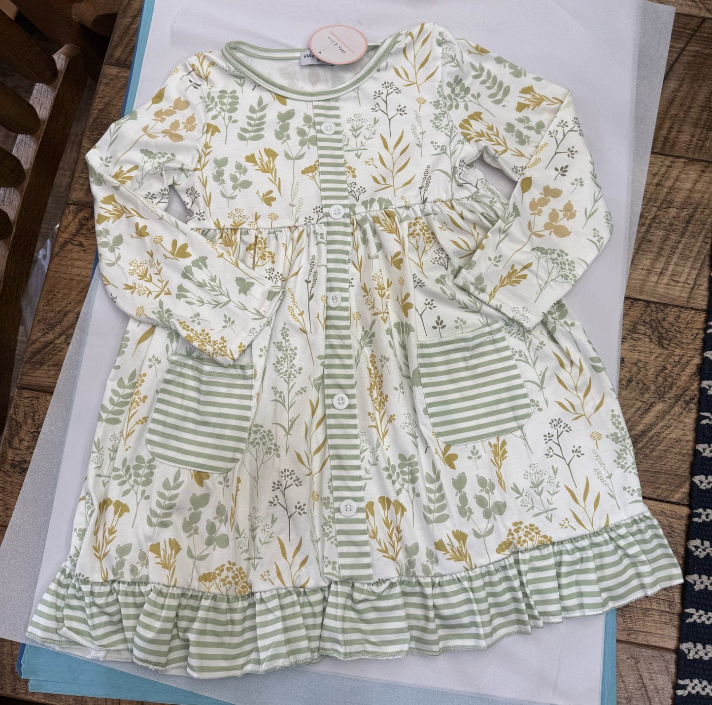 Assorted HoneyDew girls' summer dresses in navy with floral patterns, suitable for 12-month-old infants.