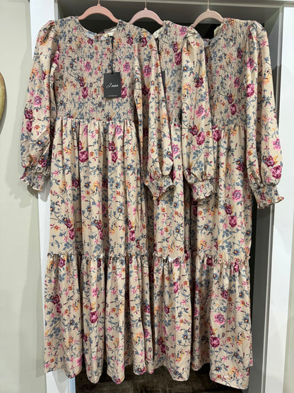 Floral print smocked tiered maxi dress by J.NNA with flowing fabric and vibrant floral pattern, perfect for summer wear.