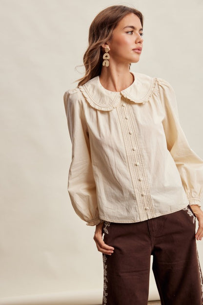 Cream long sleeve blouse by Listicle with contrast stitch Peter Pan collar, featuring a stylish and feminine design.