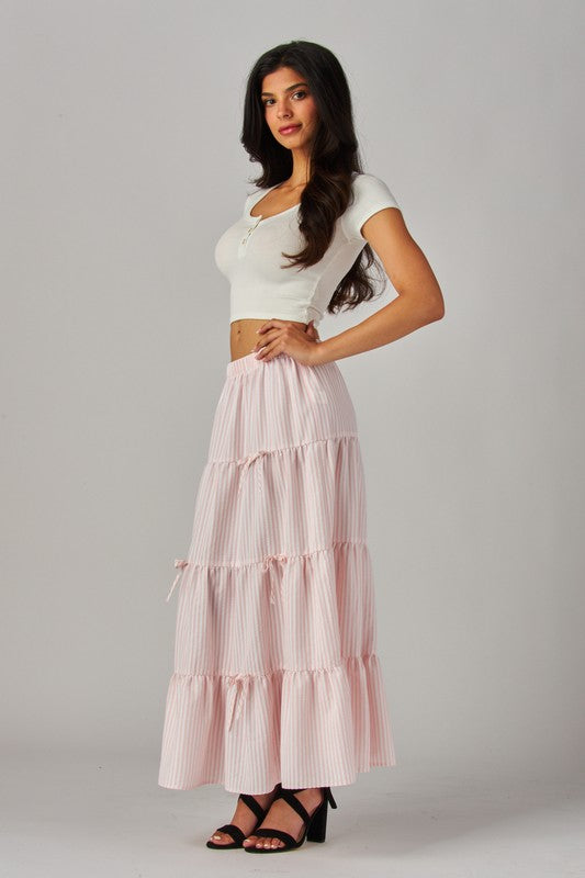 Pink Love Poem striped maxi skirt with bows, featuring a flowing design and high waist, perfect for casual or dressy occasions.