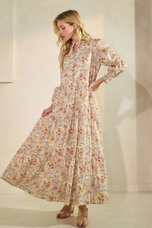 Long sleeve floral maxi dress by Lovelo featuring vibrant flower patterns and flowing fabric, perfect for elegant daytime wear.