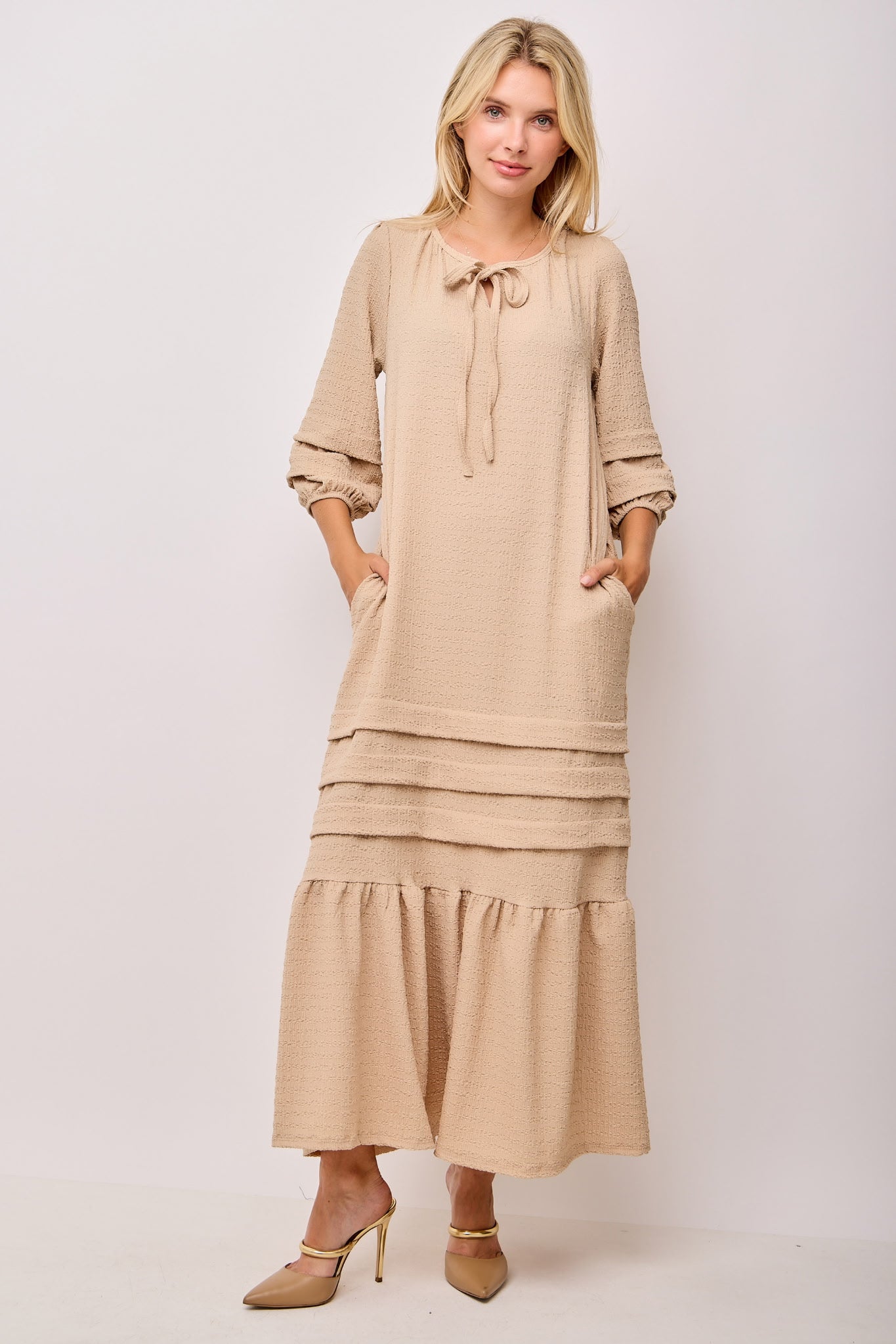 Beige textured pin tuck maxi dress with pockets by Modest and Devoted Designs, featuring a flowing silhouette and subtle detailing.