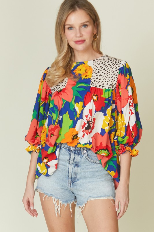 Floral mixed print blouse from Modest and Devoted Designs with a round neck, featuring colorful floral patterns on lightweight fabric.