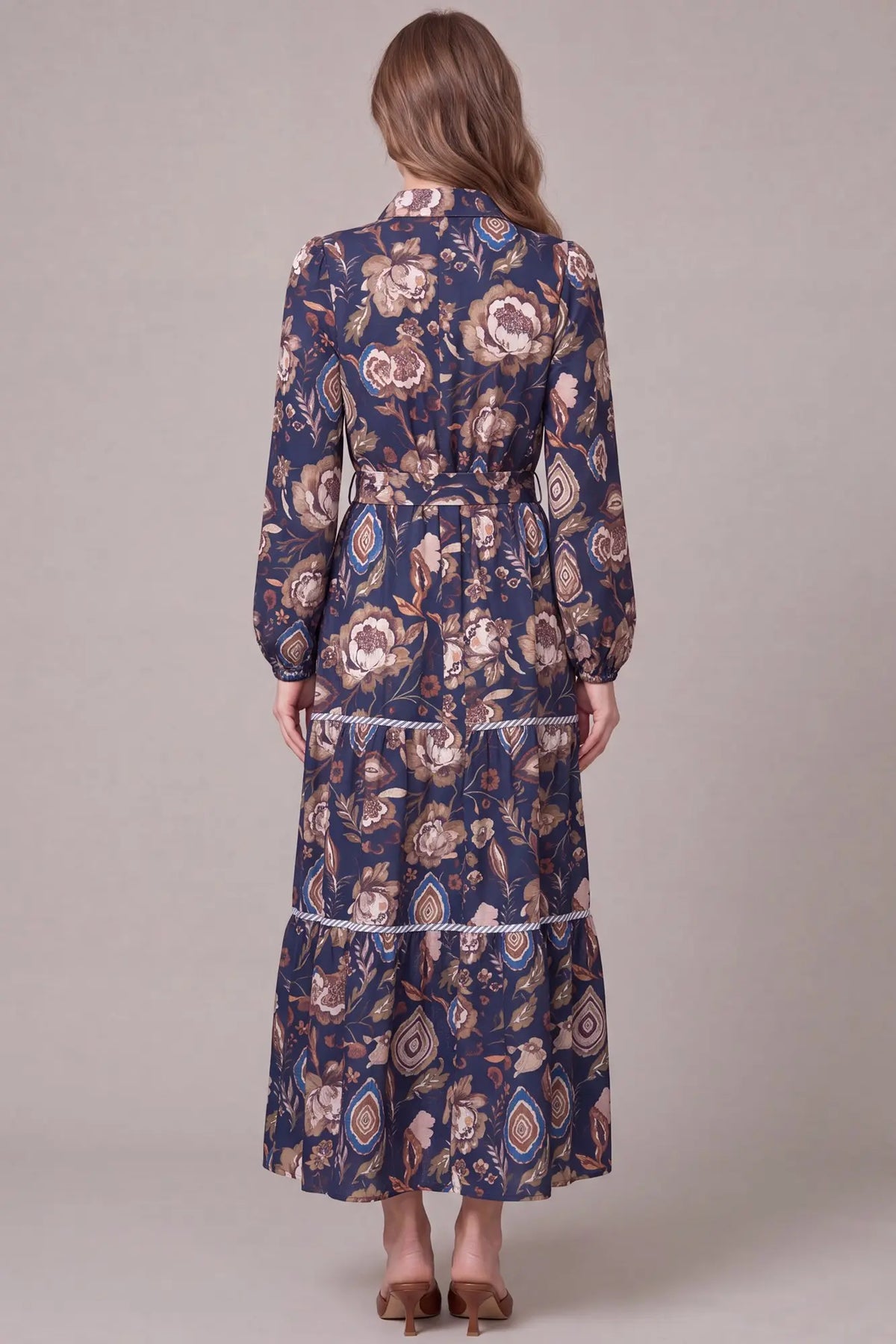 Navy long sleeve button-down paisley tiered maxi dress by ModestAndDevoted, featuring a flowing silhouette and intricate print.