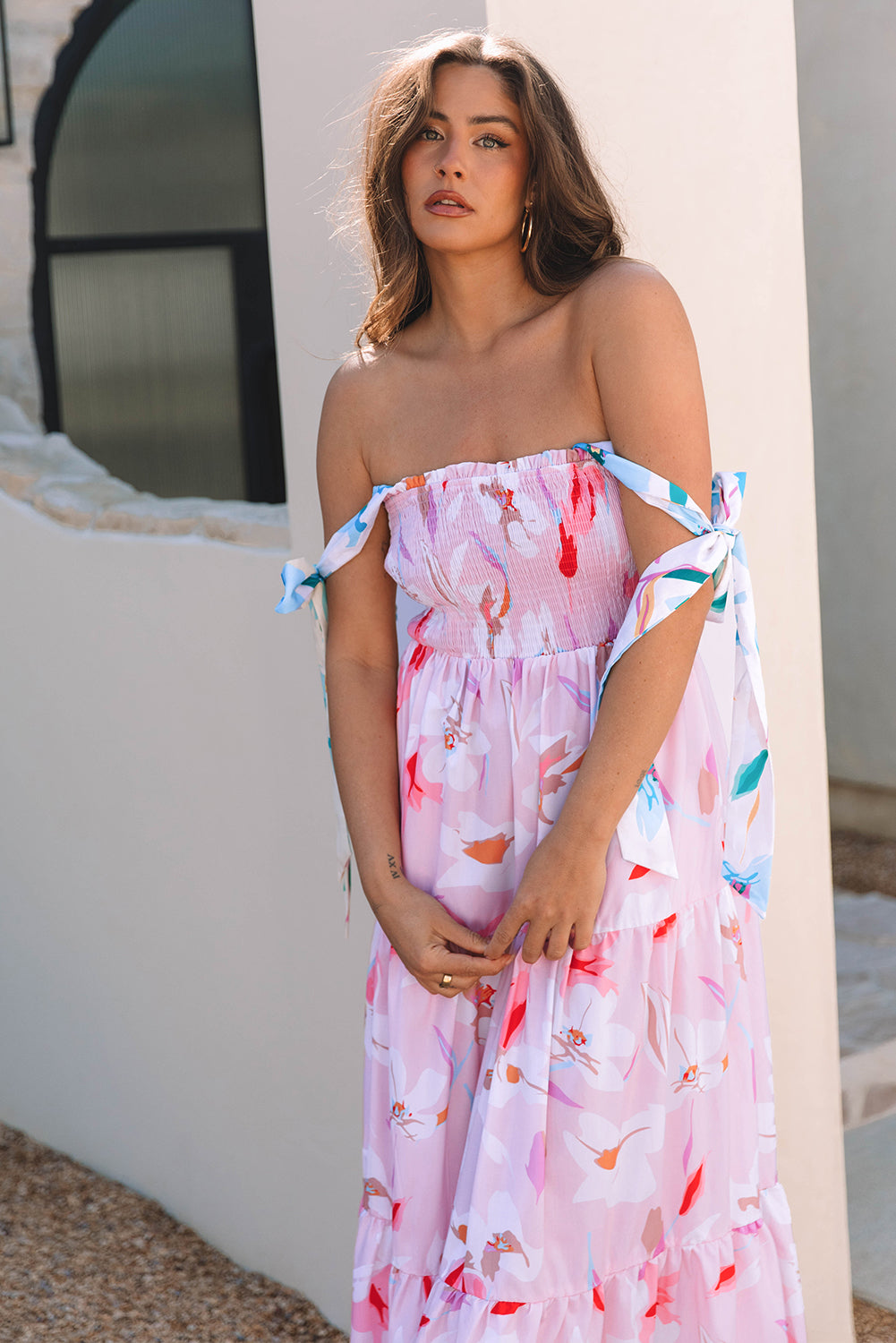Pink floral print maxi dress with knotted shoulders and smocked bodice from ModestAndDevoted, made of lightweight polyester fabric.