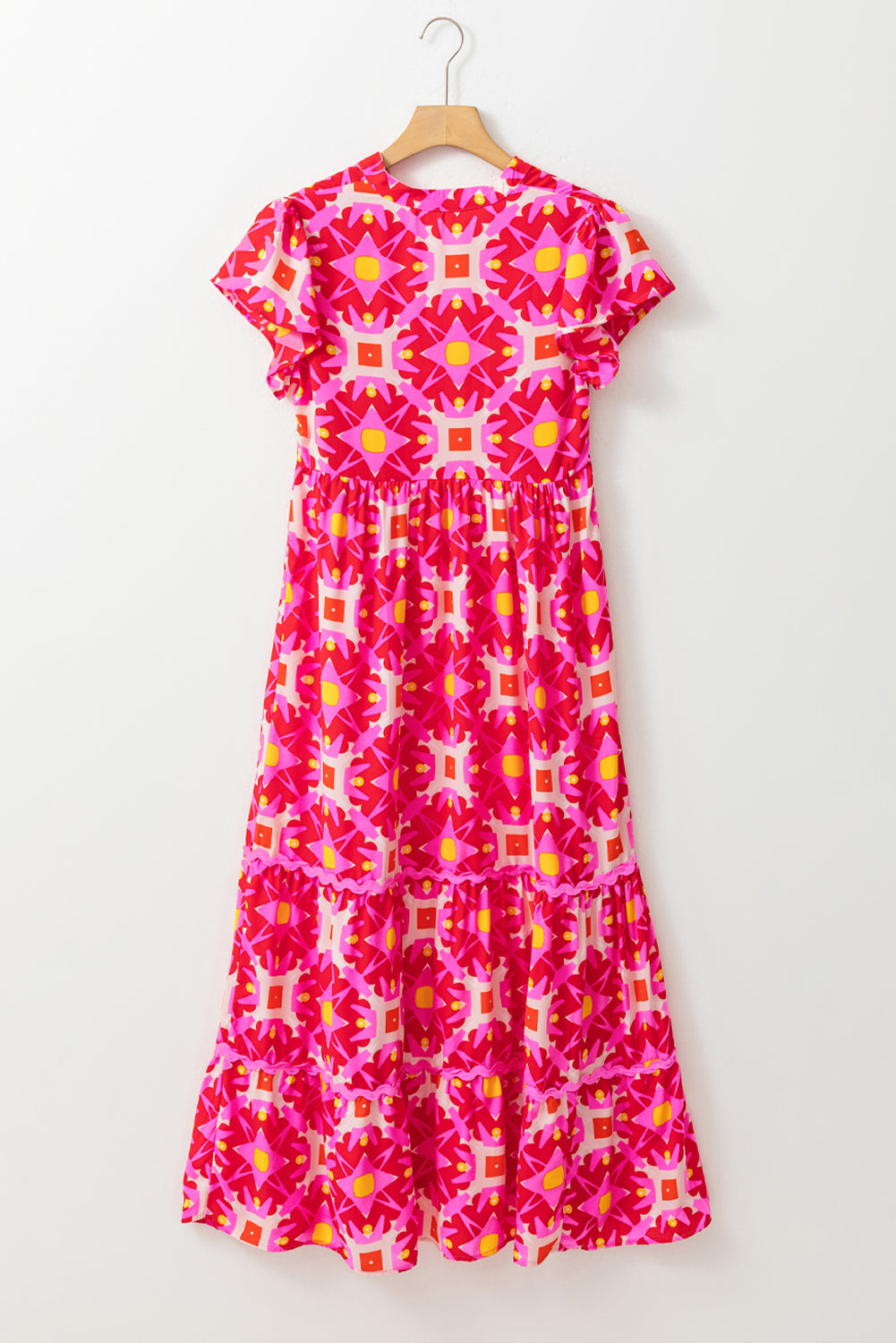 Strawberry pink geo print V-neck maxi dress by ModestAndDevoted, flowing polyester dress with a vibrant pattern and elegant V-neckline.
