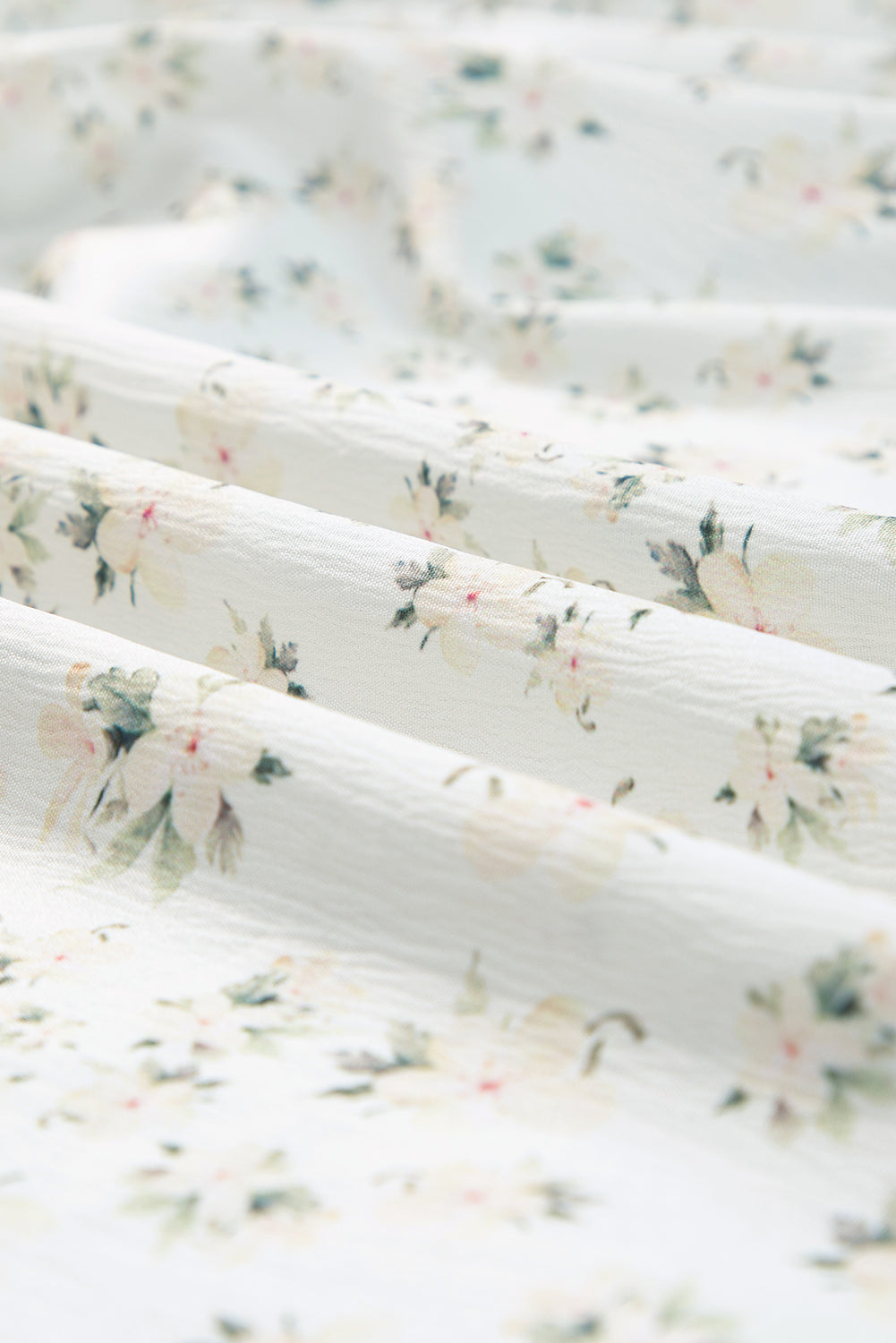 White floral maxi dress with frilly shirred bodice and tiered design from ModestAndDevoted, perfect for elegant summer wear.