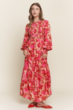 Long sleeve floral dress with smocked bodice by ModestAndDevoted, featuring bright, colorful floral print and a flowing silhouette.