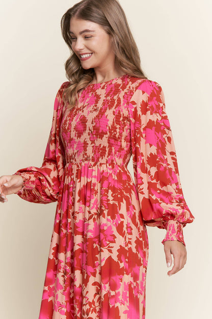 Long sleeve floral dress with smocked bodice by ModestAndDevoted, featuring bright, colorful floral patterns and a comfortable fit.