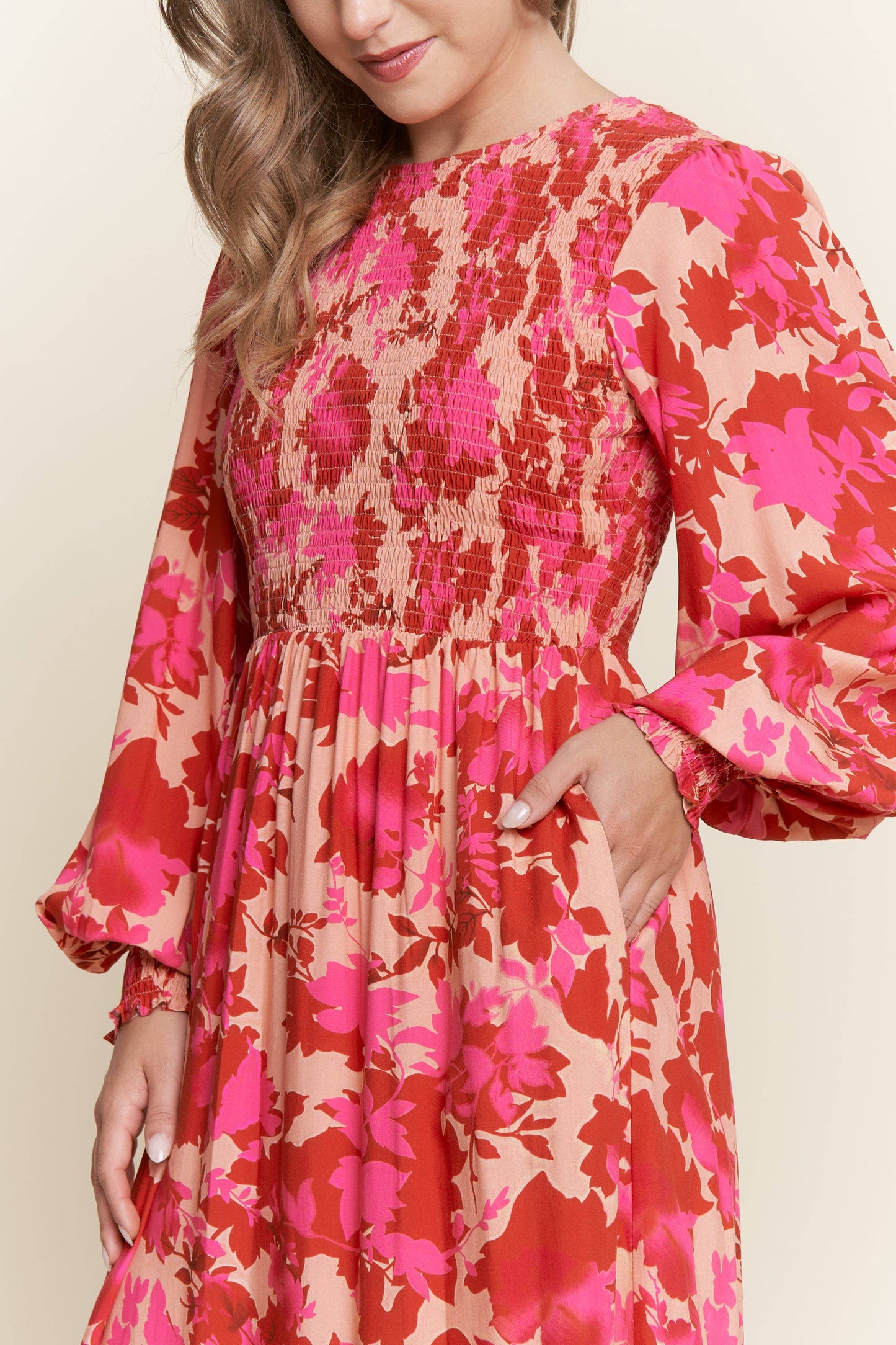 Long sleeve floral dress with smocked bodice by ModestAndDevoted, featuring bright, colorful flower print and a fitted silhouette.