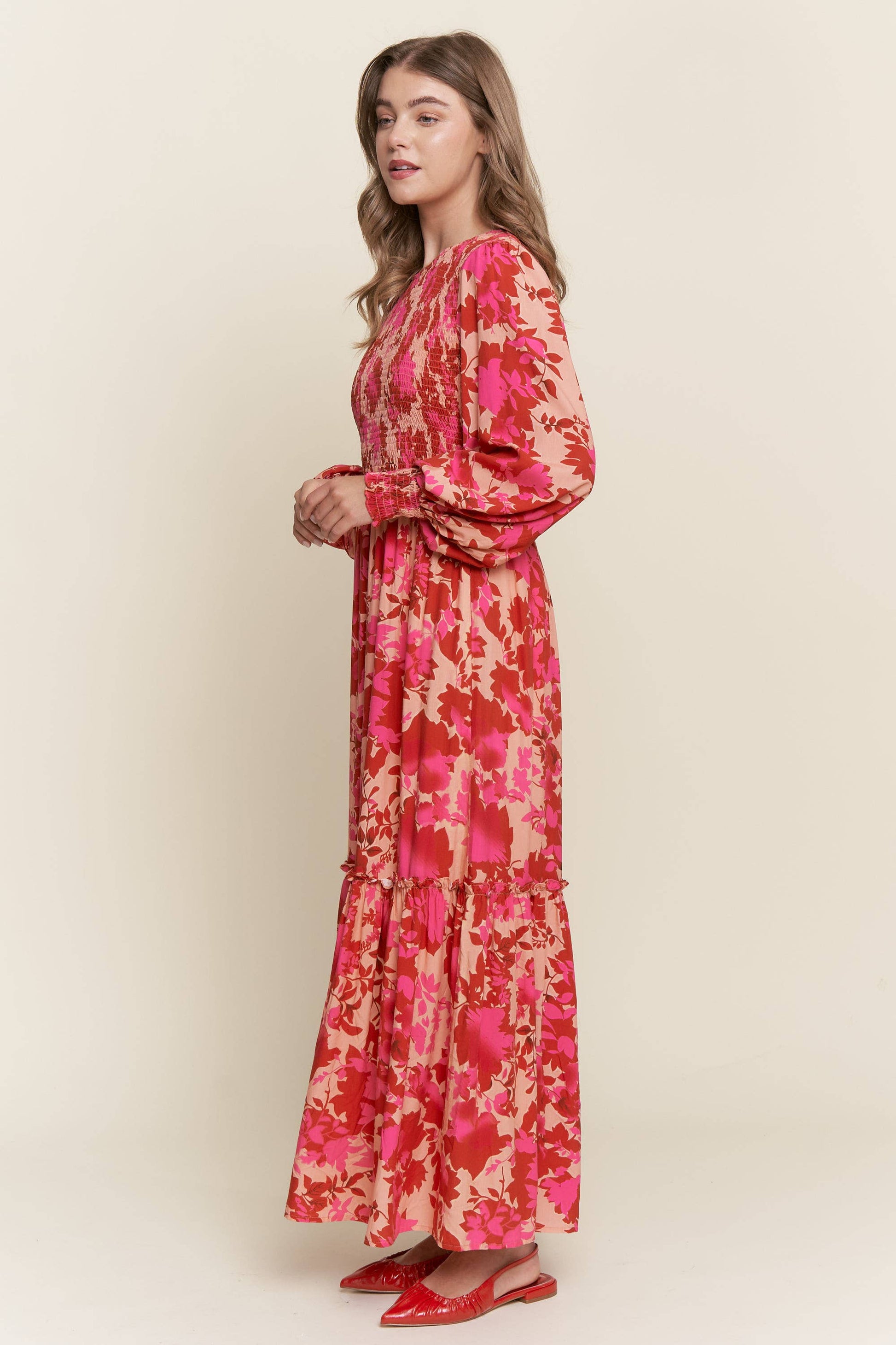 Long sleeve floral dress with smocked bodice by ModestAndDevoted, featuring bright colorful floral patterns and a feminine silhouette.