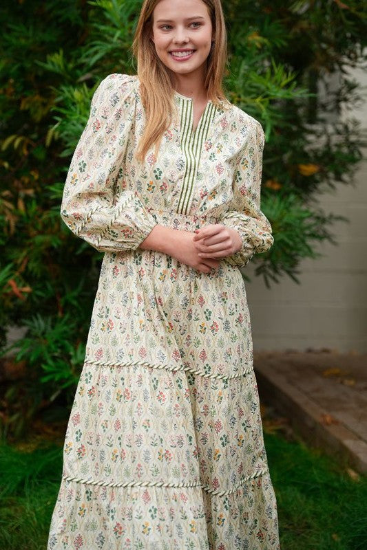 ModestAndDevoted novelty print maxi dress with pockets and detailed trim, flowing fabric, and vibrant pattern.