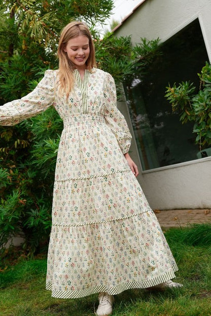 ModestAndDevoted novelty print maxi dress with pockets and detailed trim, flowing fabric, and vibrant design.